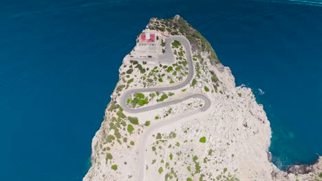 Aerial---bright-limestone-cliff-with-serpentine-road-and-lighthouse-tower