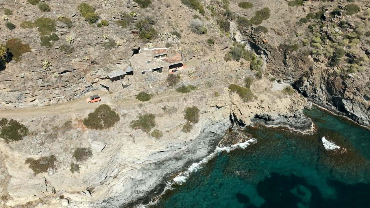 Old stone mansion on steep cliff near water in Spain, aerial drone view