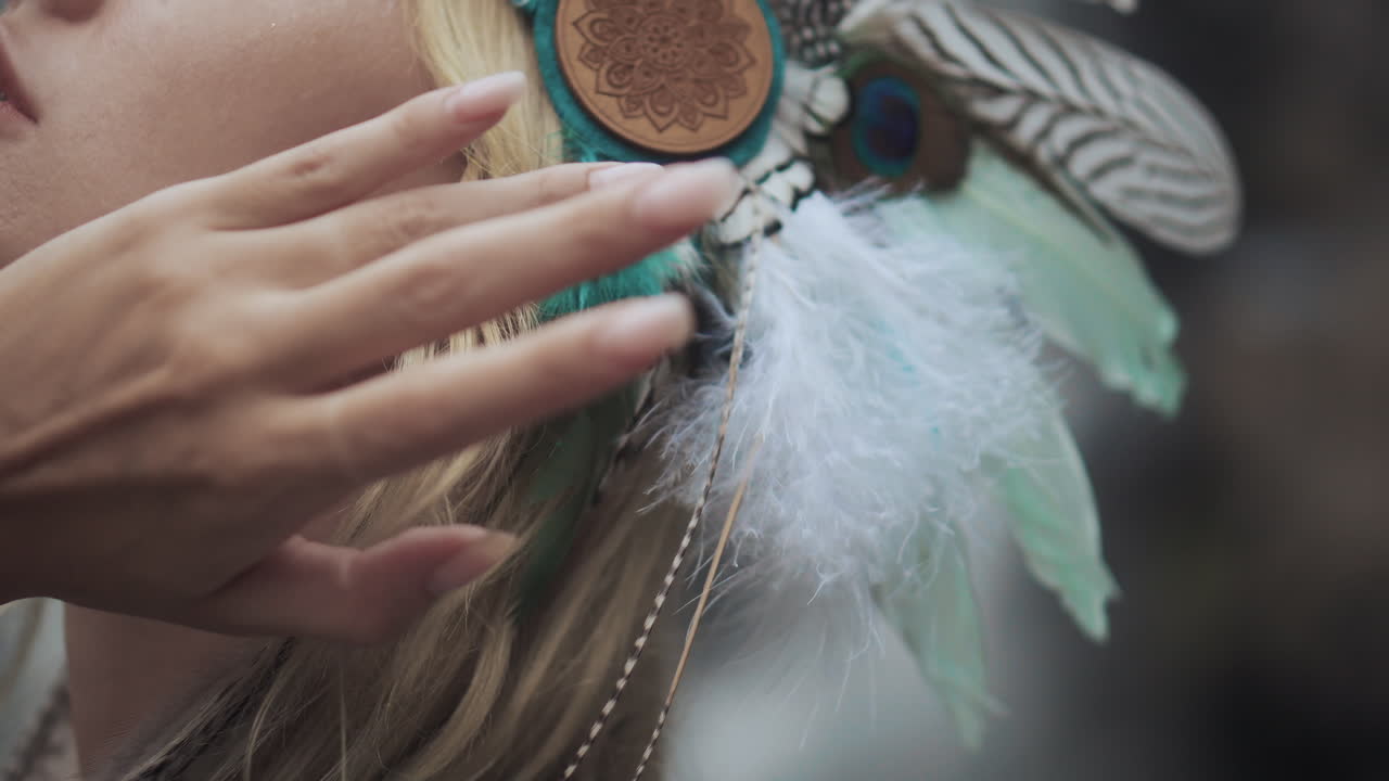 mujer con cinta tribal en la cabeza y accesorios de plumas
