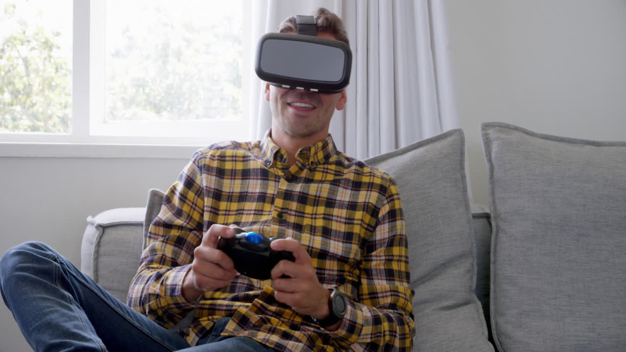 Animazione di icone di social media su un uomo caucasico che indossa un visore VR e gioca a casa.