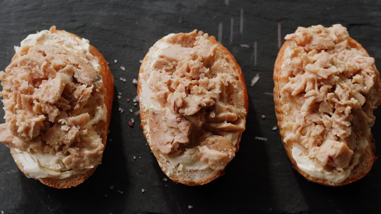 Smoked cod liver in oil in open tin can with fresh greens on wooden table. Seafoods delicacy. High quality 4k footage