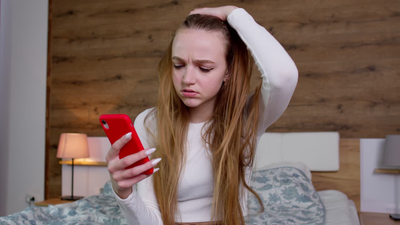 슬프고 화가 나고 불만족하고 짜증나는 소녀가 휴대전화에서 나쁜 소식을 읽고, "아니요, 필요없어요"라고 말합니다.