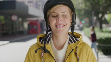 portrait of beautiful blonde woman blowing bubblegum smiling happy enjoying playful fun in vibrant urban city street wearing helmet