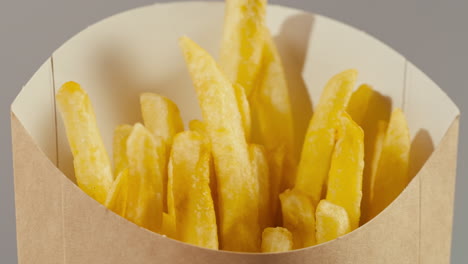 crispy french fries in paper container