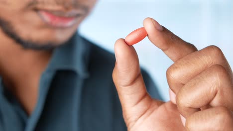 person holding a red pill