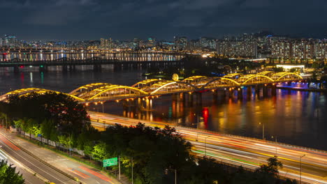 night traffic timelapse of cars driving on busy olympic expressway and illuminated hangang bridge - static