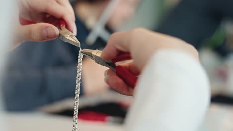 taller de joyería arreglando una pulsera de plata, vista de cerca