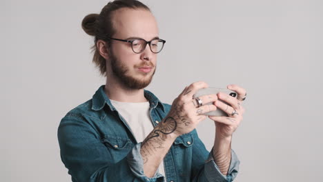 caucasian young man playing video games on smartphone and winning.