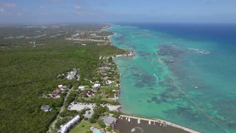 Aerial-view-towards-exotic-resorts-and-the-coastline-of-Punta-Cana,-sunny-Dominican-republic