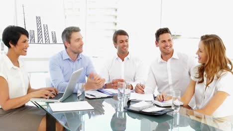 Feliz-Equipo-De-Negocios-Discutiendo-Durante-La-Reunión