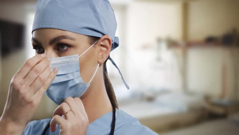 female caucasian surgeon adjusting her face mask in hospital