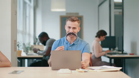 Business-man-having-fun-at-workplace.-Young-man-winking-eye-looking-at-camera