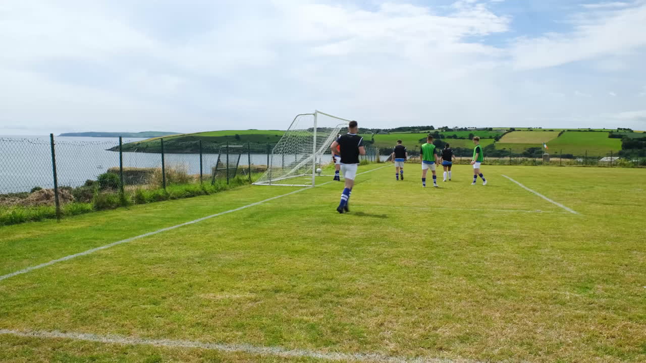 Soccer players practicing on scenic coastal field, preparing for match
