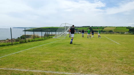 soccer players practicing on scenic coastal field, preparing for match