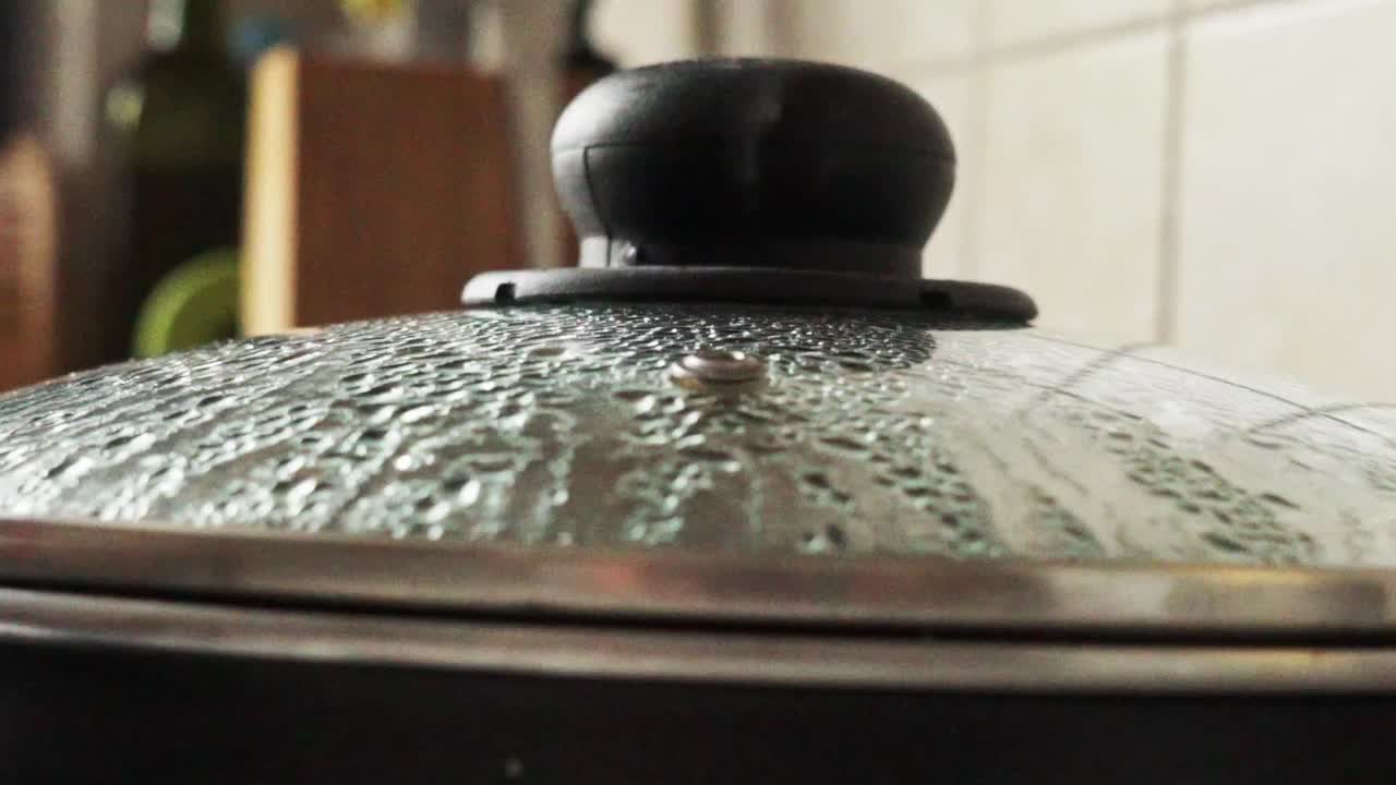 냄비의 투명한 유리 리에 닫고, 증기는 작은 구멍에서 증발하고, 궤도 보기 120fps