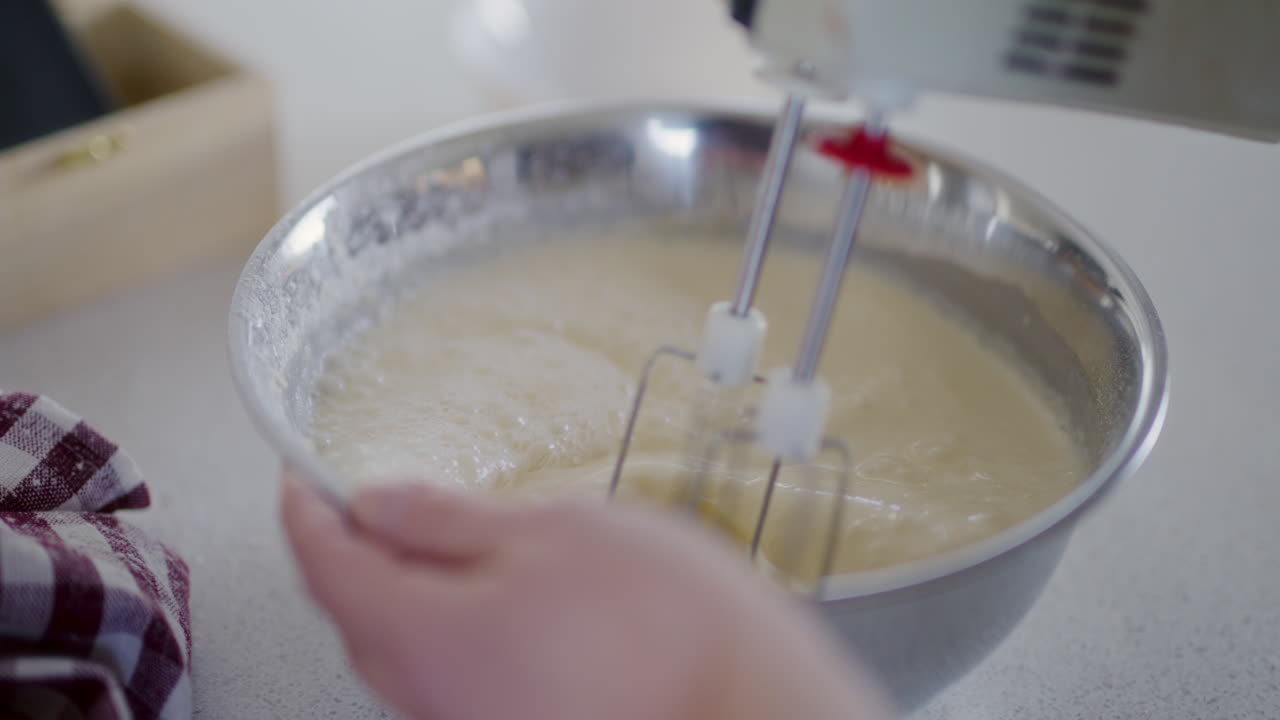 mezclador para mezclar la masa en un cuenco de metal para prepararla para hornear