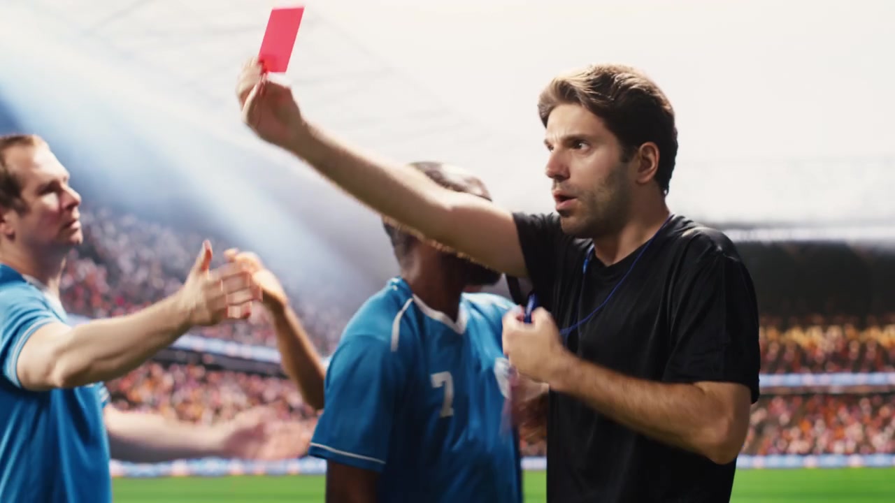 Cartellino rosso mostrato dall'arbitro di calcio con i giocatori che protestano contro la decisione di espulsione