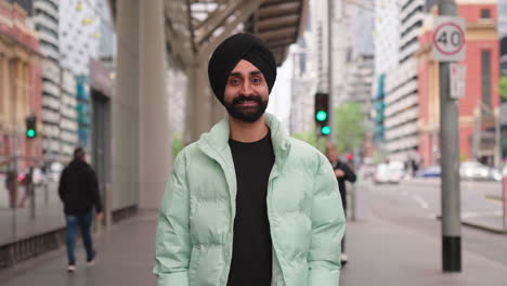 bearded indian man smiling at camera in the city