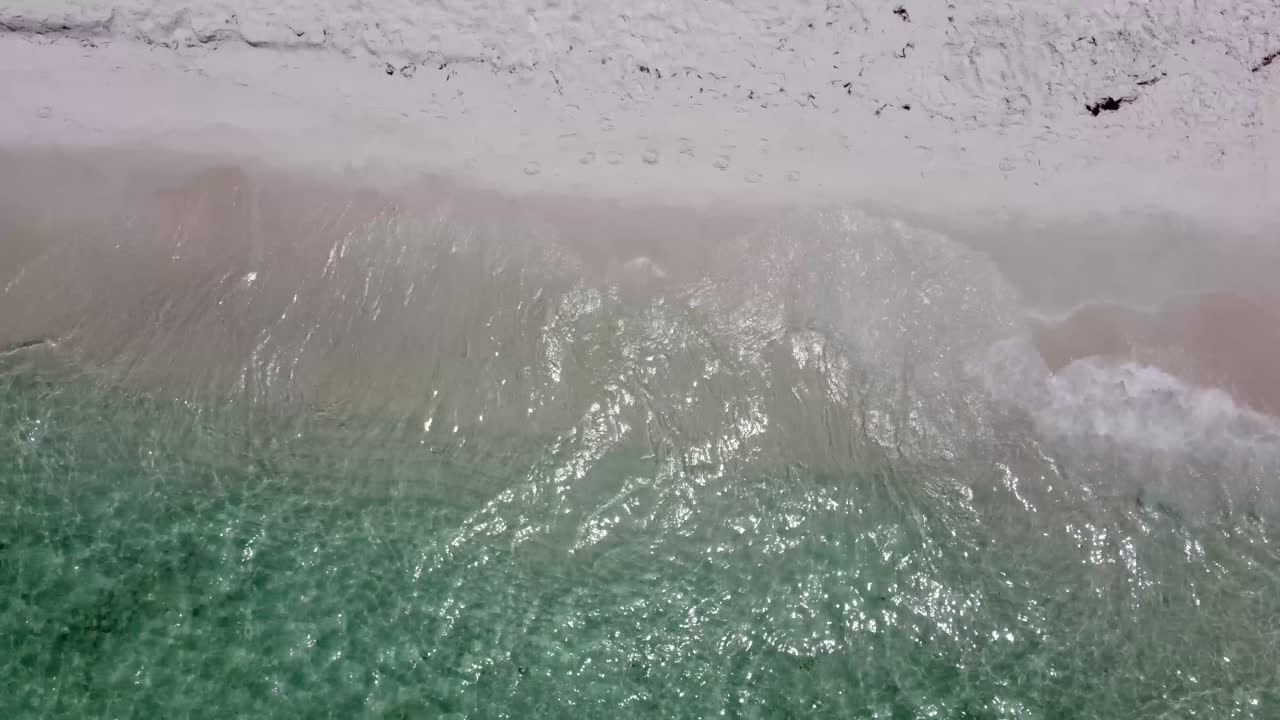 вид с дрона на красивые бесшовные бесконечные кадры, когда бирюзовые морские волны разбиваются о песчаное побережье