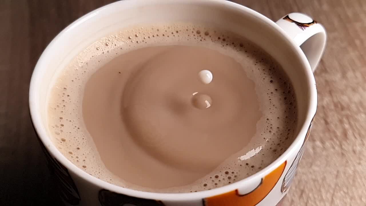 Gocce di latte in ultra slow motion che cadono in un caffè