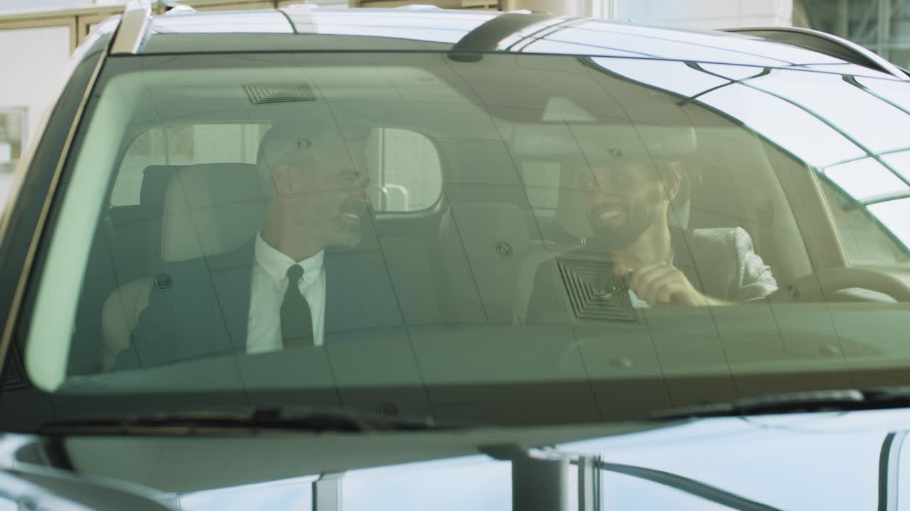 두 명의 사업가 들 이 자동차 전시실 에서 토론 하고 있다