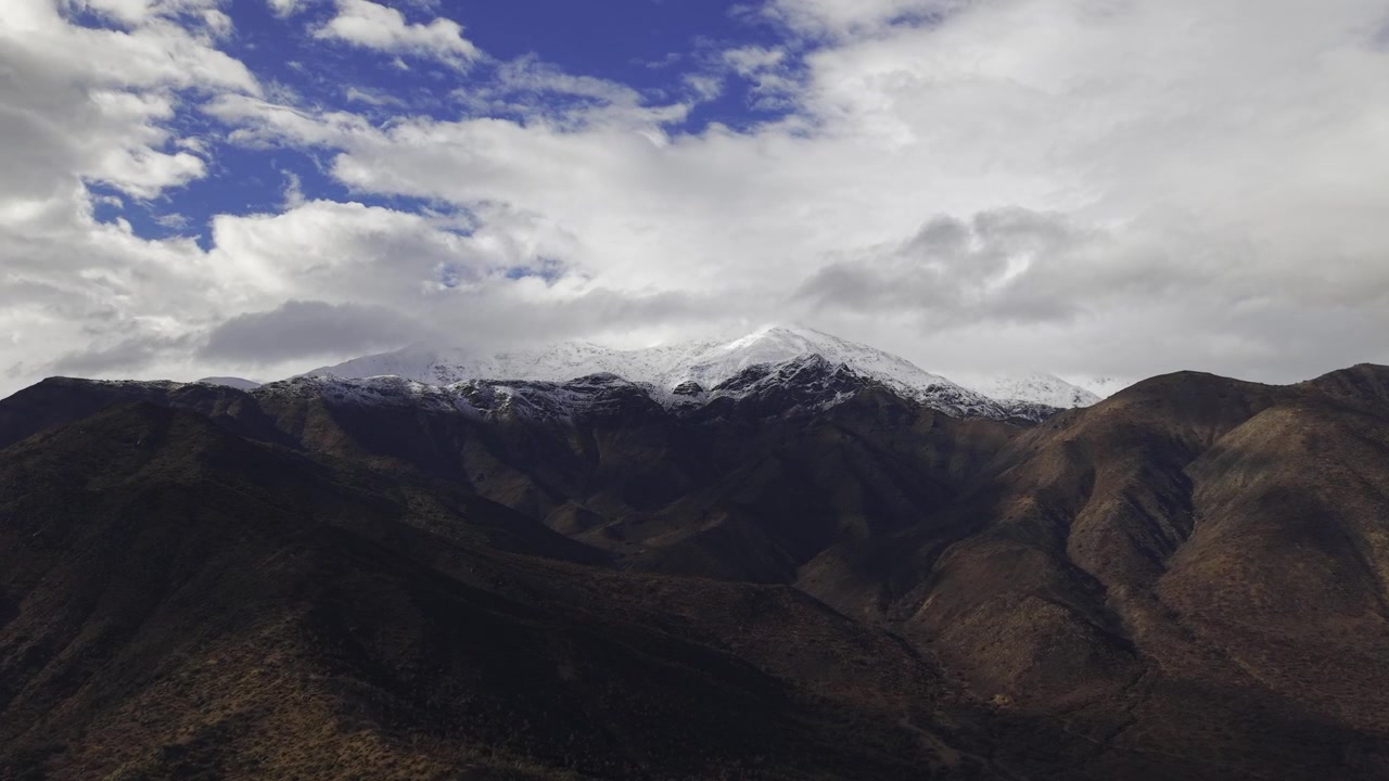 Bela vista aérea destacando o contraste entre os cumes escuros das montanhas e os picos nevados brancos e brilhantes dos Andes.