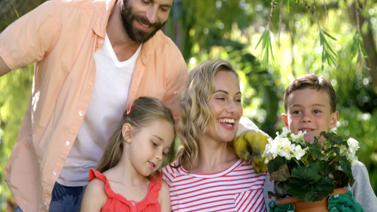 Ritratto di famiglia adorabile in posa mentre fa giardinaggio