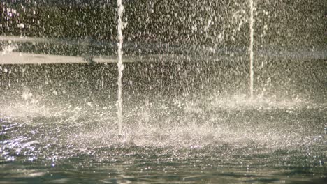 closeup of water drops spreading around fountains, abstract texture with slow motion