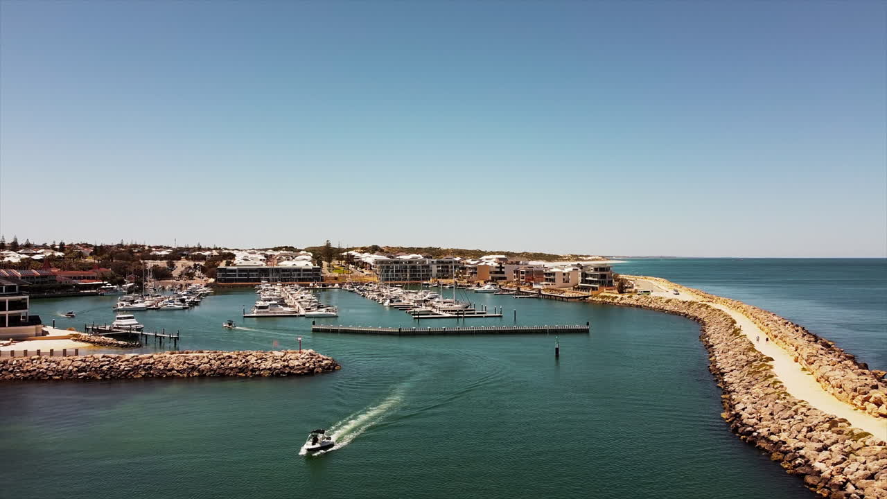 정박된 요트와 범선이 있는 고급스러운 해안 거주지에 살고 있는 정박지의 드론 보기