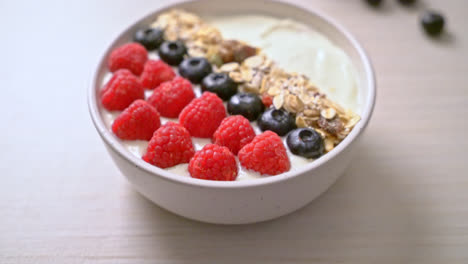 homemade yogurt bowl with raspberry, blueberry and granola - healthy food style