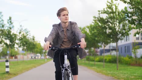 young man riding bicycle on city street