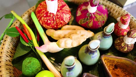 a vibrant display of herbal compresses, oils, and spices used in traditional thai massage, showcasing natural wellness elements