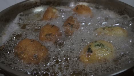 view from top codfish cakes boiling into oil pan