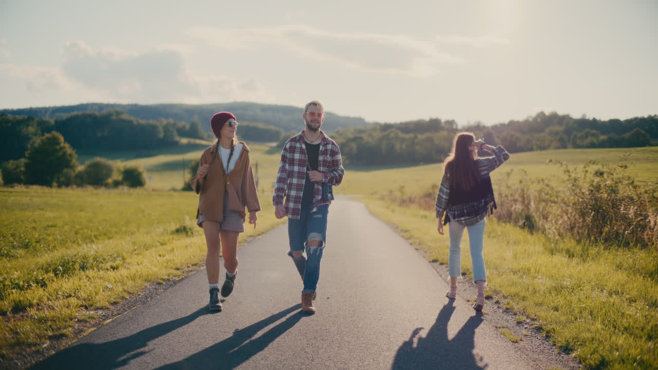 Freunde gehen an einem sonnigen Tag zusammen auf einer Straße