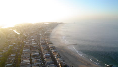 aerial view of a coastal city and beach with haze over the ocean at sunrise