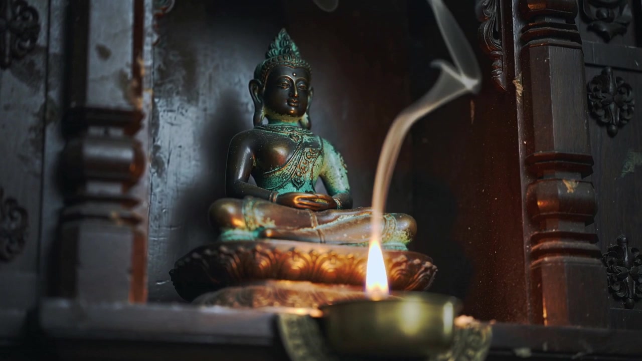 Lampada a olio in ottone accesa che sprigiona fumo di incenso a volute in un santuario intagliato, rivelando una statuetta di loto.