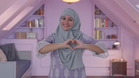 happy muslim woman showing heart sign