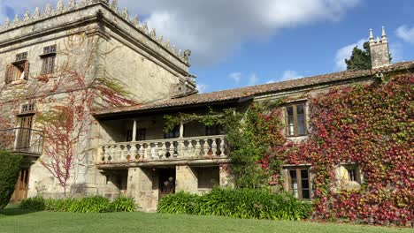 majestuoso edificio de piedra pazo en galiza cubierto de vegetación. vista panorámica