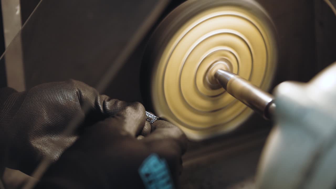 A professional jeweler meticulously polishing a ring, bringing out its shine and brilliance with expert precision and care