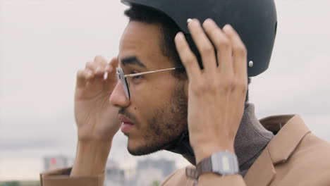 close up of a young american man in formal clothes wearing a bicycle helmet in the city