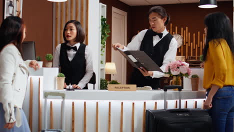 hotel employees greeting customers at front desk in lobby