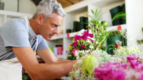 male florist arranging flower bouquet in flower shop