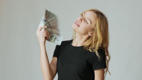 beautiful girl with a lot of dollars in the hands on the white background