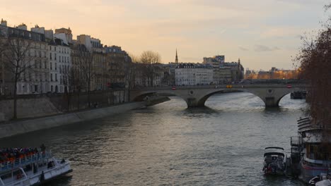 Touristisches-Ausflugsboot,-Das-In-Der-Abenddämmerung-Auf-Der-Seine-In-Paris,-Frankreich,-Segelt