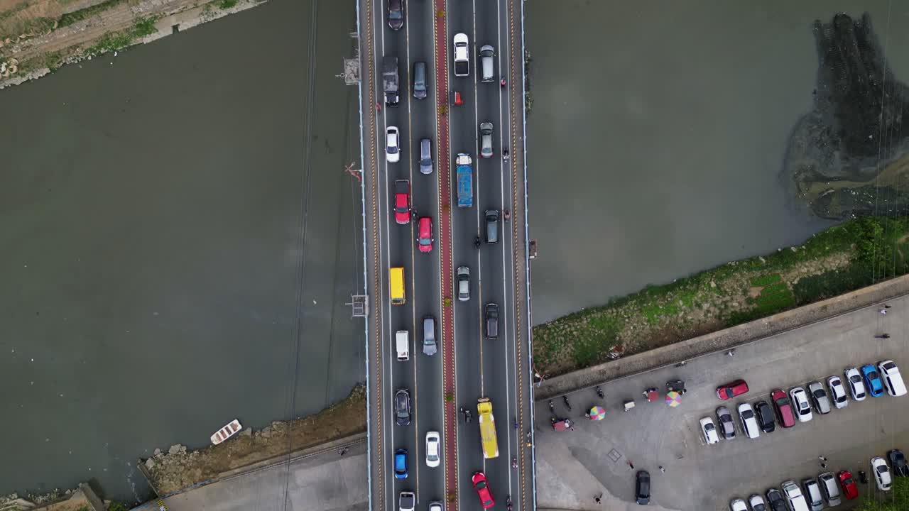 Topdown aerial of traffic over bridge spanning Marikina River, cars flowing in both directions