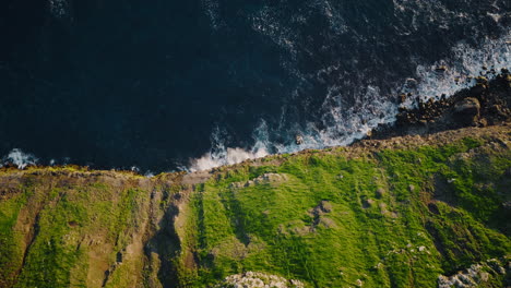 Aerial View of Rugged Green Coastal Cliffs and Crashing Ocean Waves