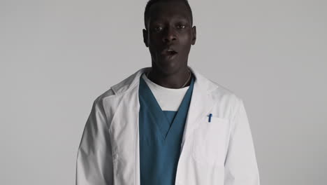 tired african american doctor on grey background.