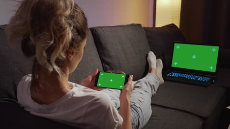 woman using phone and laptop with green screen chroma key