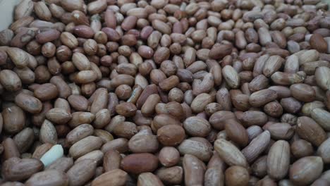 Close-up-of-peanuts-falling-into-a-bulk-bin