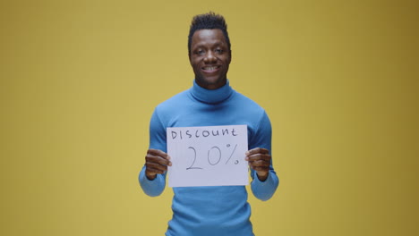 man holding a 'discount 20%' sign